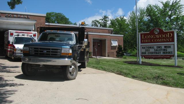 B. Bowman laying mulch around our shrubs and sign